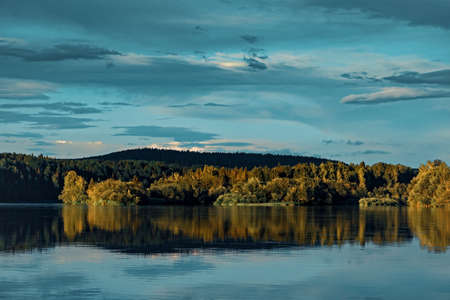 Landscape forest river Bank with reflection in the waterの写真素材