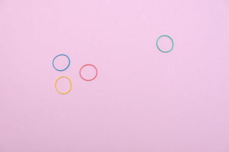 Colorful circles on pink background, flat lay. Space for text
