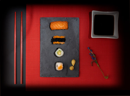 Sushi set with chopsticks and soy sauce on a red backgroundの写真素材