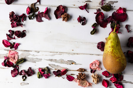 Dried rose petals and pear on a white wooden background.の写真素材