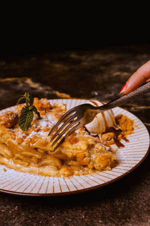 Close-up of a woman's hand holding a fork with a piece of apple pieの写真素材