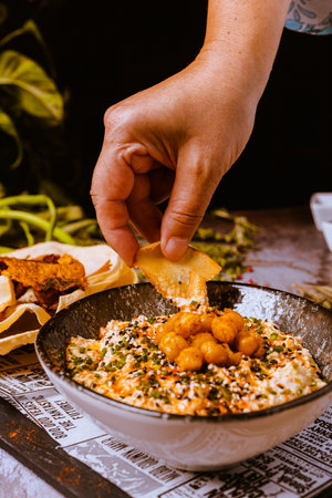 Close up of a female chef's hand adding to a bowl of fried shrimpの写真素材