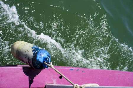 side of a pink boat on the sea の写真素材