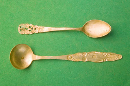 two silver spoon isolated on greenの写真素材