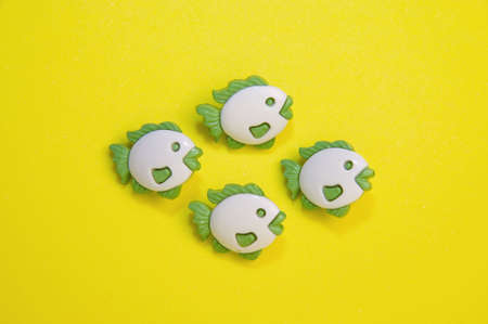 fish buttons on yellow backgroundの写真素材