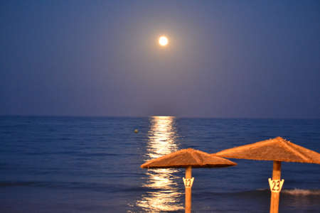 The moon rising over the horizon of the Mediterranean Sea. Photo taken from the shore of Benicasim beach, in CastellÃ³nの写真素材