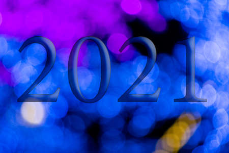 Text with the year number 2021 with a background of bright blue lights out of focus with Bokeh effect. Happy New Year 2021.の写真素材