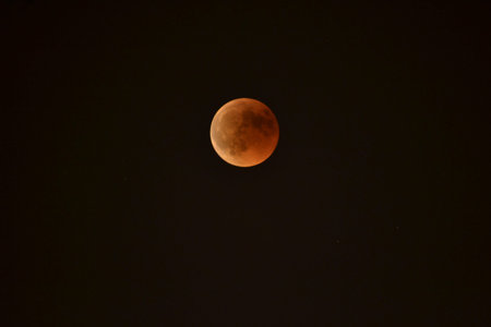 Orange moon by lunar eclipse seen from Madrid, Spain