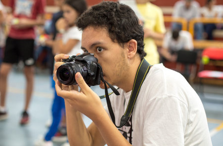 Young white boy taking a picture with a reflex camera. Photographer in action. Photographer with a...