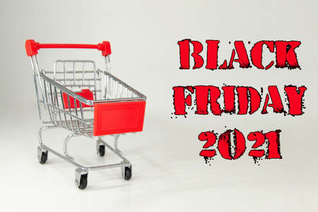 Black Friday 2021. Design for Black Friday accompanied by a metal shopping cart for the huge sales on these dates. White background. Space for text. Horizontal photography.の写真素材