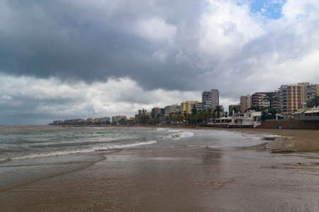 The beach of BenicÃ ssim-BenicÃ¡sim and the Mediterranean Sea joining with rainwater and floods producing a mixture of sediments leaving the water brown, in Spain. Europe. Horizontal photography.の写真素材