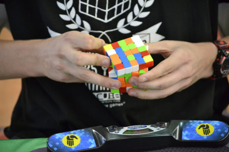 MADRID, SPAIN - SEPTEMBER 13, 2021. Close-up of hands solving a Rubik's Cube. Color puzzle.