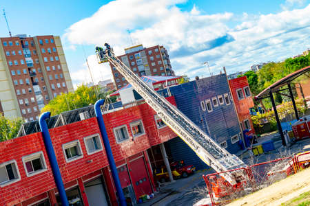 Firefighters climb a scale of a truck in one of the trainings in the fire station, in Madrid, Spain. Europe.のeditorial素材