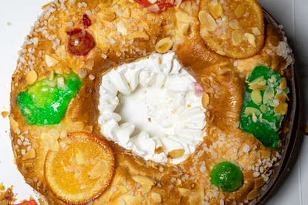 RoscÃ³n. Roscon de Reyes. Kingcake. Bun made with a sweet dough in the shape of a toroid decorated with slices of candied, candied or crystallized fruit of various colors with creamの写真素材