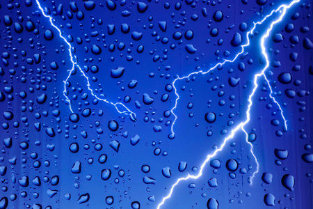 Rain. lightning. Raindrops on the window. Rainy day. Blue tone. Background with lightning. Macro...