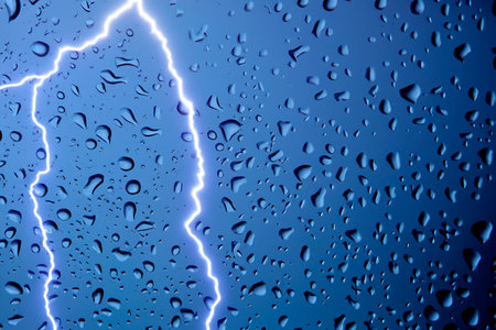 Rain. lightning. Raindrops on the window. Rainy day. Blue tone. Background with lightning. Macro photography. Texture. Autumn and spring weather concept. Background of water rainの写真素材