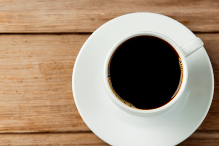 Coffee. Cup. Coffee with milk. Space for text. Design in the cafe. Close up of coffee cup with roasted coffee beans on wooden background. view from above.の素材