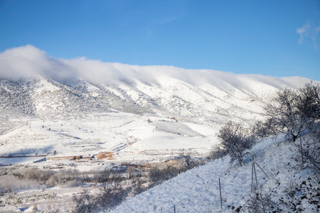 Winter landscape. Snow-covered mountains and village on a sunny dayの写真素材