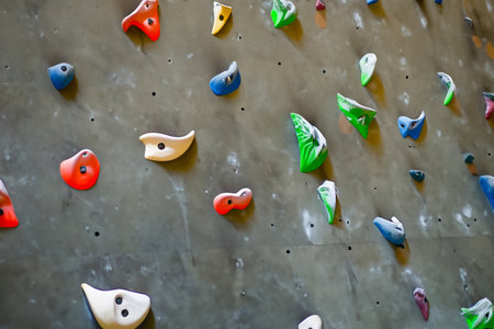 Close up of a climbing wall with colorful climbing equipment in a gymの写真素材