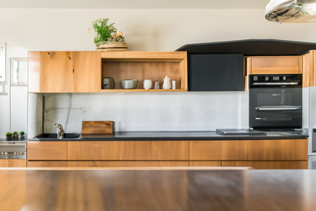 Kitchen. Kitchen island in modern luxurious kitchen interior. Contemporary kitchen with white furniture, wood accents, and marble surfaces. Modern new light.の写真素材