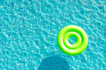 Swimming pool. Inflatable floating in swimming pool on sunny day. Top view. With space for text. Summer color concept. Summer and heat concept.の写真素材