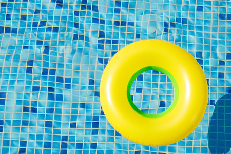 Swimming pool. Inflatable floating in swimming pool on sunny day. Top view. With space for text. Summer color concept. Summer and heat concept.の写真素材