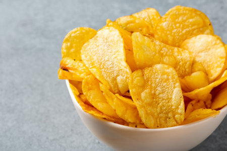 Chips. Potato chips levitate on a white background. Natural potato chips isolated. Potato chips piled up. Potato chips in bowl. Fast food.の写真素材