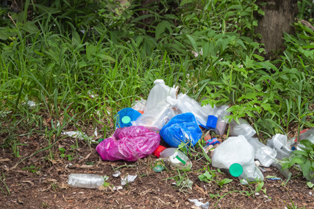 Rubbish. Liter. Garbage in nature. Group of eco volunteers picking up plastic trash in park. Activists collecting garbage, protecting the planet, avoiding pollution and saving the environmentの写真素材