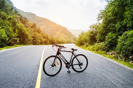 Bike. Bicycle. Road bike parked on a beautiful road sunset, warm light with copy space. Road bike parked on a beautiful road sunset, warm light. World bicycle day.の写真素材