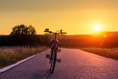 Bike. Bicycle. Road bike parked on a beautiful road sunset, warm light with copy space. Road bike parked on a beautiful road sunset, warm light. World bicycle day.の写真素材