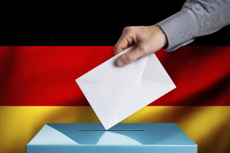 Elections. Hand of a person who votes at the polls during the elections. Envelope with the ballot on election day to choose your candidate. Ballot. Box. Voting. 2025. Germany. 23.の写真素材