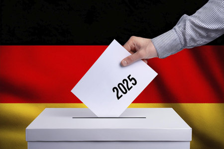 Elections. Hand of a person who votes at the polls during the elections. Envelope with the ballot on election day to choose your candidate. Ballot. Box. Voting. 2025. Germany. 23.の写真素材