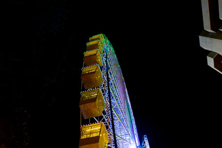 Ferris wheel. Noria. Christmas lights in Vigo, Pontevedra. Christmas decorations. Tourists strolling through its streets. Ferris wheel in the dark showing neon colors. VIGO. SPAIN.の写真素材