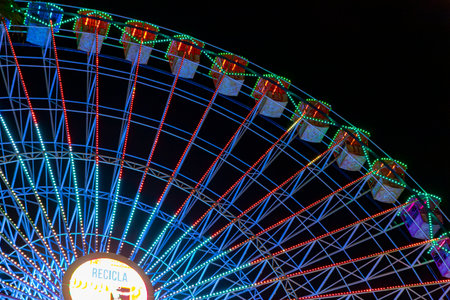 Ferris wheel. Noria. Christmas lights in Vigo, Pontevedra. Christmas decorations. Tourists strolling through its streets. Ferris wheel in the dark showing neon colors. VIGO. SPAIN.の写真素材