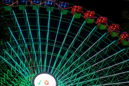 Ferris wheel. Noria. Christmas lights in Vigo, Pontevedra. Christmas decorations. Tourists strolling through its streets. Ferris wheel in the dark showing neon colors. VIGO. SPAIN.の写真素材