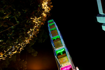 Ferris wheel. Noria. Christmas lights in Vigo, Pontevedra. Christmas decorations. Tourists strolling through its streets. Ferris wheel in the dark showing neon colors. VIGO. SPAIN.の写真素材
