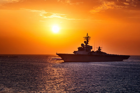 Aircraft carrier on sea near Iraq over sunset. Conflict in the Middle East. War between Iran and Israel with the participation of countries such as the United States and Russia.の写真素材