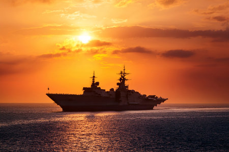 Aircraft carrier on sea near Iraq over sunset. Conflict in the Middle East. War between Iran and Israel with the participation of countries such as the United States and Russia.の写真素材