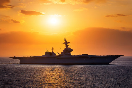 Aircraft carrier on sea over sunset.の写真素材