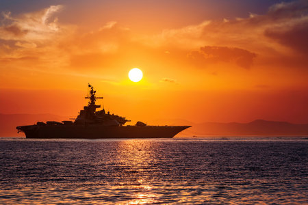 Aircraft carrier on sea over sunset.の写真素材