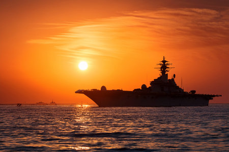 Silhouette of a warship at sunset in the sea.の写真素材