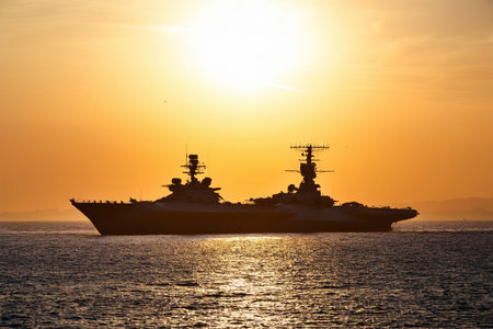 Silhouette of the aircraft carrier in the sea at sunset.の写真素材