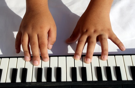 Child hands playing portable musical instrument の写真素材