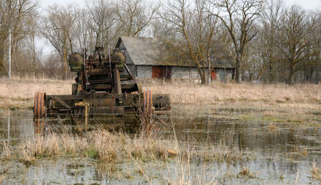 antique abandoned road grader in countryside (made in former USSR) against old barnの写真素材