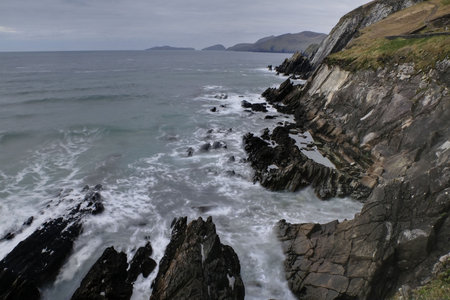 Beat of waves at rocky beach in Dingle peninsula during windy sunset
