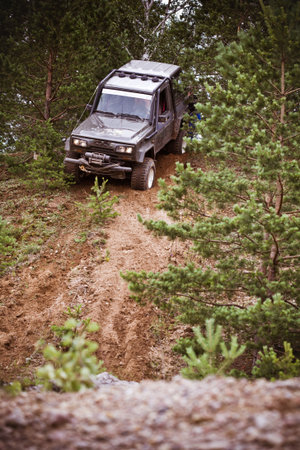 Closeup of 4x4 truck driving downhill  on the edge of hill