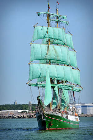 sailboat going out of port with full sails upの写真素材