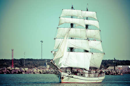 sailboat going out of port with full sails up cross-process lookの写真素材