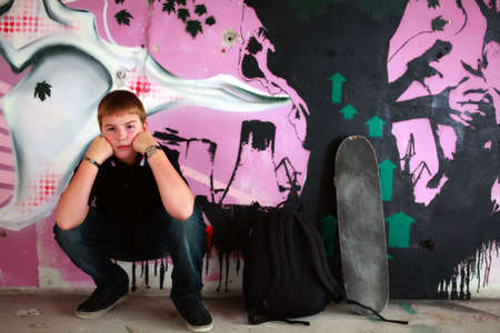 Teenage boy with skateboard against purple graffity wall check out more of the same seriesの写真素材