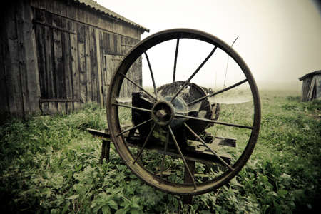 Vintage manual gras chopping machine in the misty autumn morning agaisnt barn, bleached colorsの写真素材
